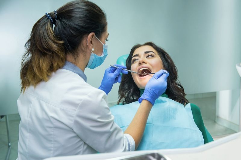 Dentist examining teeth at Sujay's Dental Care